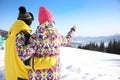 Young couple at ski resort, space for text. Winter vacation Royalty Free Stock Photo