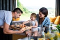 Young couple with small daughter indoors, weekend away in container house in countryside.