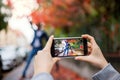 Young couple with smartphone making video for social media outdoors on street. Royalty Free Stock Photo