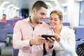 Young couple with smartphones in train Royalty Free Stock Photo