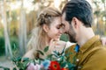 A young couple smile and touching foreheads. Autumn wedding ceremony outdoors. Bride and groom look at each other with