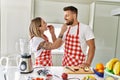 Young couple smiling confident giving fruit to each other at kitchen Royalty Free Stock Photo
