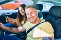 Young couple smiling happy driving car and using gps navigator smartphone Royalty Free Stock Photo