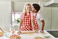 Young couple smiling happy kneading dough with hands at kitchen Royalty Free Stock Photo