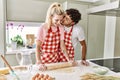 Young couple smiling happy kneading dough with hands at kitchen Royalty Free Stock Photo