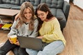 Young couple smiling happy using laptop drinking coffee at home Royalty Free Stock Photo