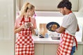 Young couple smiling happy washing dishes and drinking coffe at kitchen Royalty Free Stock Photo