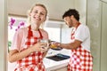Young couple smiling happy washing dishes and drinking coffe at kitchen Royalty Free Stock Photo