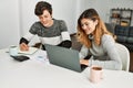 Young couple smiling happy working using laptop sitting on the table at home Royalty Free Stock Photo