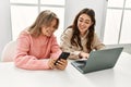 Young couple smiling happy working using laptop and smartphone at home Royalty Free Stock Photo