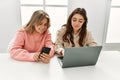 Young couple smiling happy working using laptop and smartphone at home Royalty Free Stock Photo