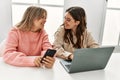 Young couple smiling happy working using laptop and smartphone at home Royalty Free Stock Photo