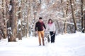 Young couple smiling and having fun in winter park with their husky dog Royalty Free Stock Photo