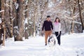 Young couple smiling and having fun in winter park with their husky dog Royalty Free Stock Photo