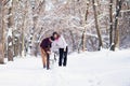 Young couple smiling and having fun in winter park with their husky dog Royalty Free Stock Photo