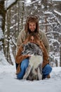 Young couple smiling and having fun in winter park with their husky dog Royalty Free Stock Photo