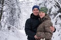 Young couple smiling while hiking in a snow covered forest