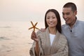 Young Couple Smiling and Looking At a Seashell Royalty Free Stock Photo