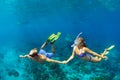 Young couple in snorkeling mask free dive underwater in sea