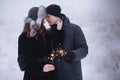 Young couple with sparklers in winter forest. Smiling family with bengal lights. Royalty Free Stock Photo