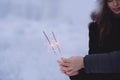 Young couple with sparklers in winter forest. Smiling family with bengal lights. Royalty Free Stock Photo