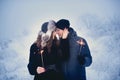 Young couple with sparklers in winter forest. Smiling family with bengal lights. Royalty Free Stock Photo