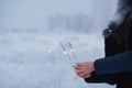 Young couple with sparklers in winter forest. Smiling family with bengal lights. Royalty Free Stock Photo