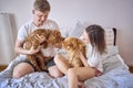 young couple spending time with their animals, a red cat and a cockapoo girl, playing and laughing Royalty Free Stock Photo