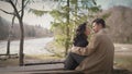 A young couple spends a romantic date on the banks of the river, enjoying the beauty of nature and reciprocity in an