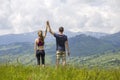 Young couple, sportive man and slim woman holding hands outdoors on background of beautiful mountain landscape on sunny summer day Royalty Free Stock Photo