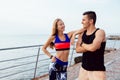 Young couple in sportswear standing on the pier near the sea Royalty Free Stock Photo