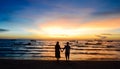 Young couple standing on beach when sunset