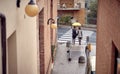 A young couple is standing on the crosswalk while walking the city on a rainy day. Walk, rain, city, relationship