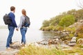 Young couple standing by a lake admiring the view Royalty Free Stock Photo