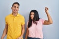 Young couple standing over isolated background dancing happy and cheerful, smiling moving casual and confident listening to music Royalty Free Stock Photo