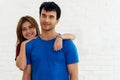 Couple standing in the room. Woman hugging her boyfriend look at camera and smiling in living room. Handsome young man with Royalty Free Stock Photo