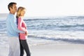 Young Couple Standing On Sandy Beach Looking Out To Sea Royalty Free Stock Photo