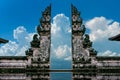 Young couple standing in temple gates and holding hands of each other at Lempuyang Luhur temple in Bali, Indonesia. Vintage tone