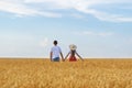 Young couple stands in wheat field and holding hands. Loving young couple outside Royalty Free Stock Photo