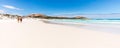 A young couple stoll along on the prisitine white sand beach and sparkling waters of Wharton Bay in the Cape LeGrande National