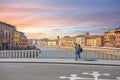 A young couple stops on a bridge over the River Arno to take a photo selfie in the Tuscan city of Pisa Italy Royalty Free Stock Photo
