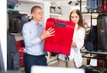 Young couple in a store chooses a travel suitcase