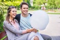 Young couple strolling in the park and eating cotton candy