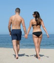 Young couple strolling on sandy beach Royalty Free Stock Photo