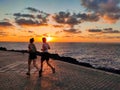 A young couple strolling at sunrise on the coast, Caleta de Fuste, Fuerteventura, Canary Islands, Spain