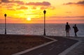 A young couple strolling at sunrise on the coast, Caleta de Fuste, Fuerteventura, Canary Islands, Spain