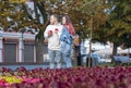 A young couple of students in love - a beautiful girl and a nice guy on the street with cups of coffee in the summer. Royalty Free Stock Photo