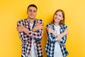 Young couple of students, man and woman with laptop on yellow background Royalty Free Stock Photo