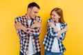 Young couple of students, man and woman with laptop on yellow background Royalty Free Stock Photo