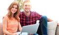 Young couple of students uses a laptop sitting on sofa Royalty Free Stock Photo